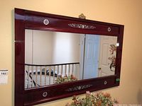 Front view of the wooden framed mirror showing the reflective surface and frame design.