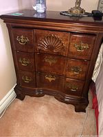 Full front view showing serpentine profile, carved shell motif and brass hardware