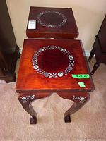 Top view showing matching circular floral inlaid patterns on two square wooden side tables.