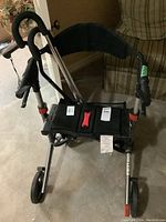 Escape folding walker front view showing seat, hand grips, wheels, and frame structure.