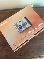 The original Canon PowerShot A560 camera box with image of the camera and key features like 7.1 megapixels and 4x optical zoom noted on front.