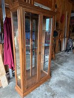 Full view of wooden china cabinet with glass doors and visible crown molding.