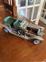 Side angle showing detailed engine block, green textured seats, and silver body.