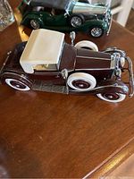 Dark brown 1938 Alvis model car with white soft top roof, whitewall tires and chrome details