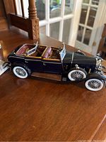 Side view of the navy blue 1926 Mercedes Benz Franklin convertible model with brown seats and whitewall tires