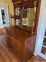 Front and side angled view of antique wooden hutch showing drawers, mirrors and wood details
