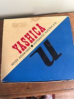 Original box of the Yashica Reflex Zoom Lens Automatic Electric Eye movie camera with branding and color design.
