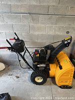 Side view of snow blower in garage showing overall condition