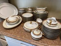 Wide view showing the full collection of dishes and serving pieces arranged on kitchen counter.