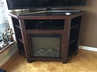 Front view of console table showing central electric fireplace insert and equipment on top