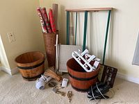 Wide view of various household items grouped together including barrels, paper cutters, a woven basket with gift wrap paper rolls, small broom, hair dryer, small scale and padlocks with keys.