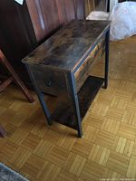 Full view of wood occasional table showing top, sides, metal frame, and lower shelf