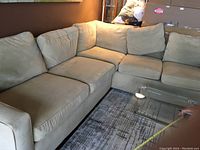 Assembled two-piece sectional couch front view with measuring tape across seating area