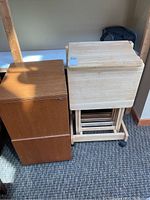 Side view showing the dark brown filing cabinet next to the wooden TV tables on the rack