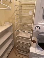 Tall combined wire drawer units with 8 wire basket drawers in total, connected with duct tape, in a laundry or storage room setting.