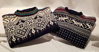 Two folded pullovers side by side showing front patterns