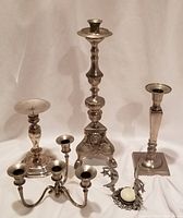 View of full set of five metal candleholders showing their different styles and heights.