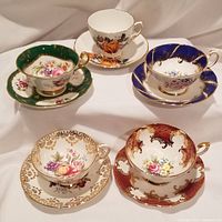 All five teacups with matching saucers arranged