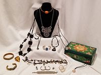 Complete view showing all jewelry pieces arranged with the wooden storage box to the right, necklaces on a black display, and bracelets, pendants, and earrings grouped in front.