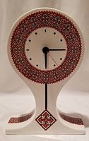 Front full view of ceramic clock showing overall shape and embroidery pattern design.