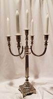 Full view of the 5-arm candelabra holding five white taper candles with detailed arms and central column.