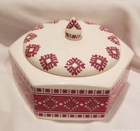 Top view of the cream hexagonal covered bowl with red embroidery-style transferware decoration on lid and sides.