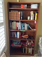 Full view of bookshelf with all shelves filled with books and small items