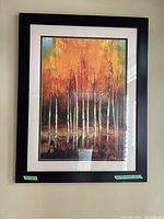 Full view of the framed artwork showing birch trees with autumn foliage in a black frame under glass.