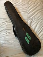 Closed black violin case with handle, showing exterior wear and tape label reading 'Lot #145 Violin'