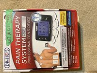 Box of Dr. Ho's Pain Therapy System Pro TENS Device showing front cover and pain relief claims.