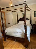 Full front view of queen canopy bed with bedding installed