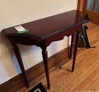 Wood hall table shown from the front and side angles, displaying beveled edge top and turned legs.