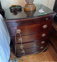 Three-quarter view showing overall shape, bow front and bracket feet