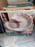 Closed box of boxed 12-piece The Pioneer Woman dinnerware set with floral details on packaging.