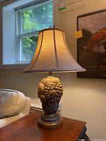 Full view of one table lamp with shade on showing height and setting