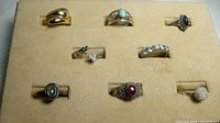 Overview photo of 8 rings in display case showing variety of designs and stones