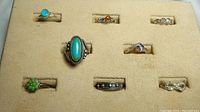 Eight sterling silver rings with assorted stones displayed in beige ring tray