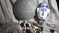 Photo showing the Millennium Falcon toy, Death Star replica, R2-D2 figure, X-Wing fighter, and 8 Star Wars character action figures.