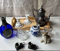 Cobalt glass decanter, silver plate teapot, white milk glass candlesticks, wooden tray, blue and white porcelain ginger jar, clear glass and bulldog figurine