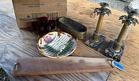 Showing entire lot including cherry live edge charcuterie board with metal ring handles, antique brass and marble candlesticks, vintage brass planter, cranberry glass tumblers, and majolica asparagus plate.