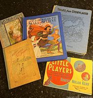 Five antique children's books displayed together showing front covers and condition.