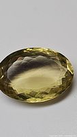 Close-up photo of natural oval cut lemon citrine gemstone with facets and high luster