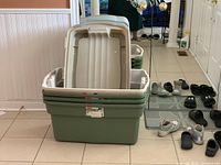 Four stacked green Rubbermaid RoughTote storage bins with beige lids in very good condition.