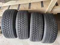 Four tires standing upright on wooden platform