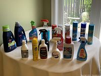 Front view of all cleaning products arranged on a white surface showing labels and spray nozzles.