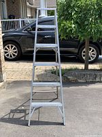 Front view of metal step ladder showing all four steps and top platform.