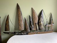 Front angled view of the metal sailboat wall decor showing all sails and chain connections.