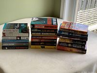 Stack of novels showing spines, including multiple Sandra Brown titles and others by Beverly Barton, Robert Barnard, Jefferson Bass, Sidney Bauer.