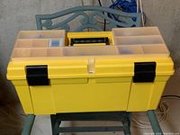 Closed yellow Mastercraft plastic toolbox with black handle and locking latches.