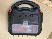 Black Craftsman carrying case for mouse sander with molded handle and clear accessory compartment, showing brand name on lid.